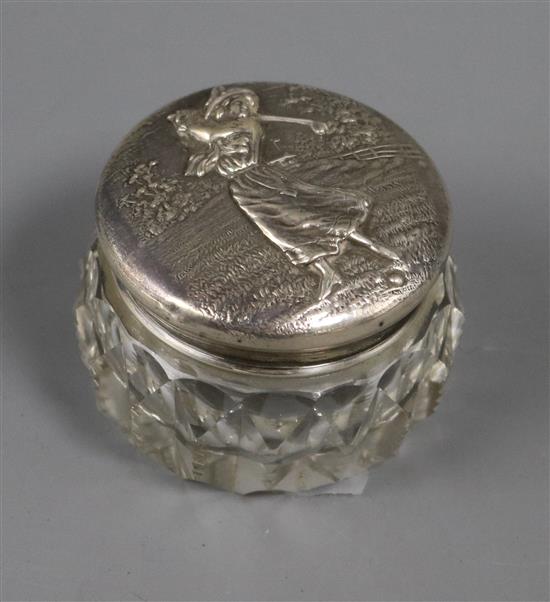 A sterling silver mounted glass toilet jar, the lid embossed with a lady golfer, 55mm.
